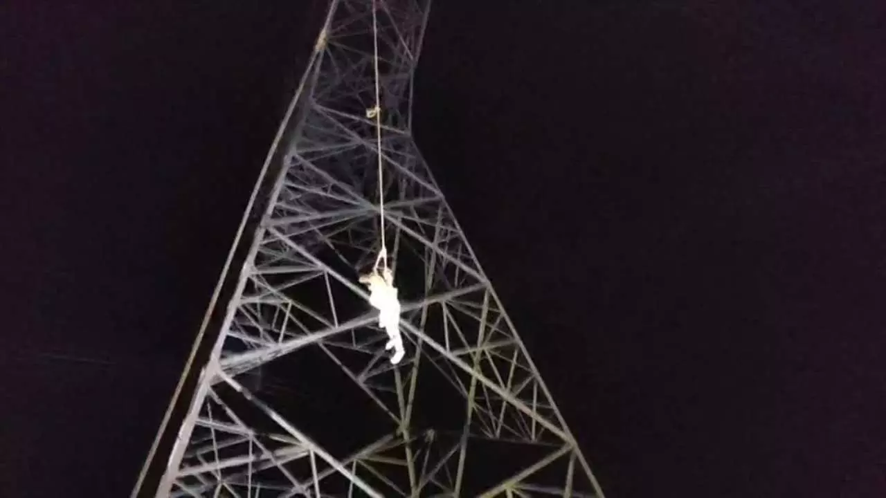 High voltage drama of a young man who climbed a high tension tower